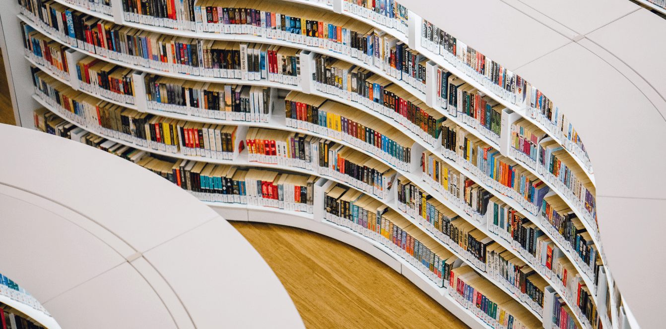 Geschwungene Bücherregale in einer modernen Bibliothek, Symbolbild für Dekarbonisierung der Buch- und Verlagsbranche
